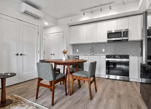 A modern kitchen with a dining table and chairs.