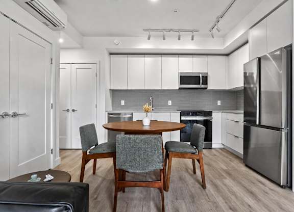 A modern kitchen with a dining table set for two.