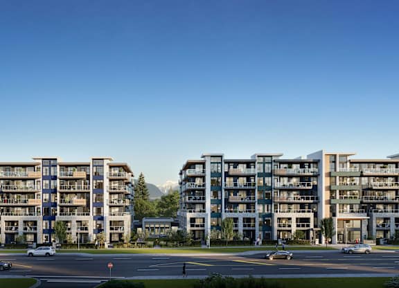 A large apartment complex with a parking lot in front.