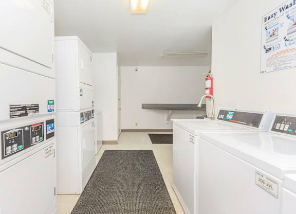 A laundromat with a row of washers and dryers.
