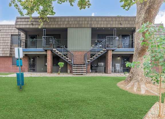 A building with a green lawn in front.