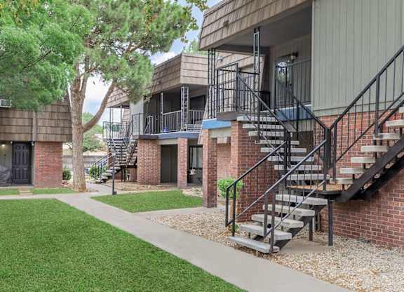 A building with a staircase and a tree in front.