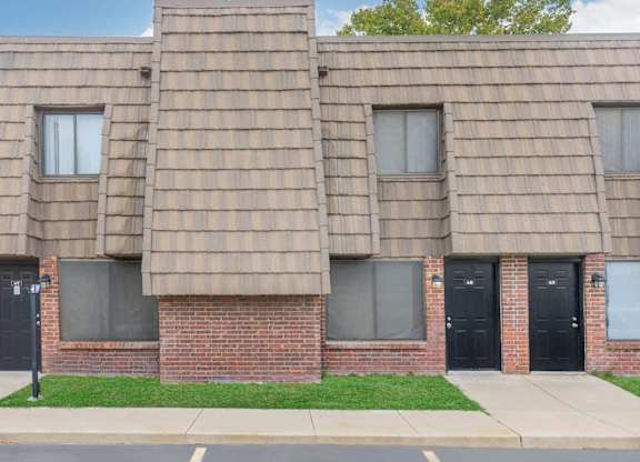 A building with a brown shingled roof and black doors.