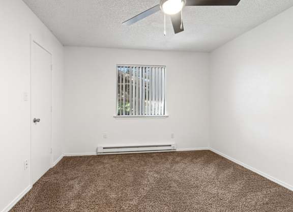 A room with a window and a ceiling fan.