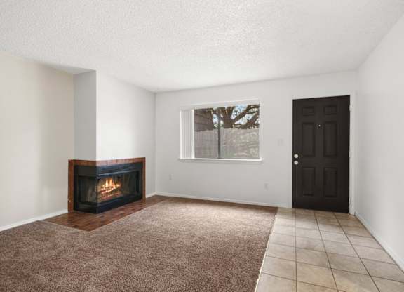 A room with a fireplace and a brown carpet.