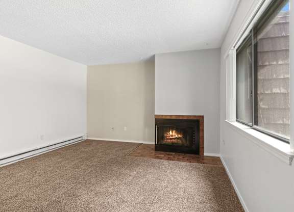 A room with a fireplace and carpeted floor.