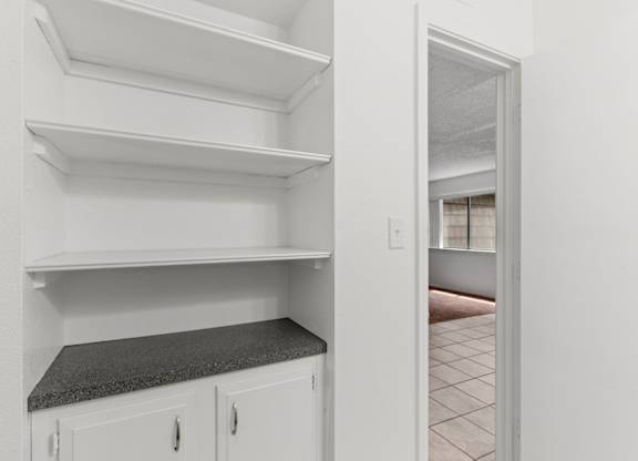 Empty white shelves in a kitchen.