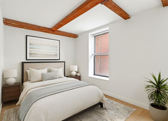A bedroom with a large bed and a potted plant.