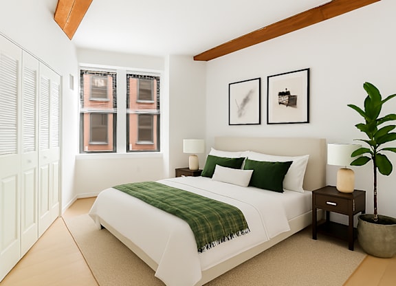 A bedroom with a bed, nightstands, and a plant.