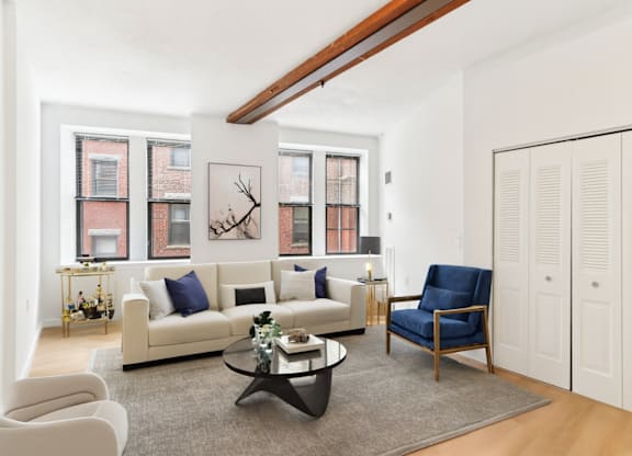 A living room with a white couch, a blue chair, and a coffee table.