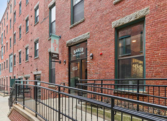 A red brick building with a black railing in front.