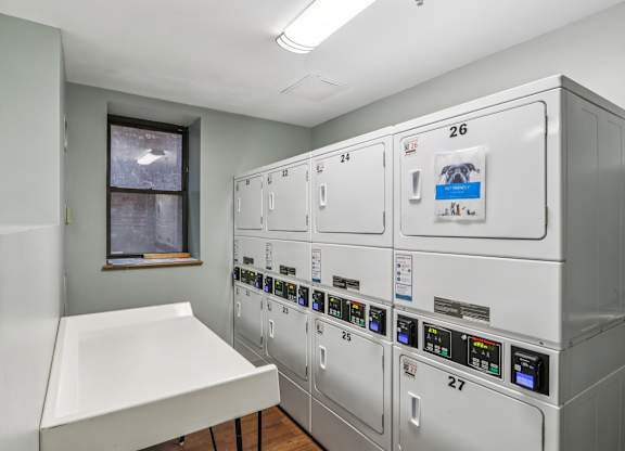 A row of white refrigerators are lined up in a room.