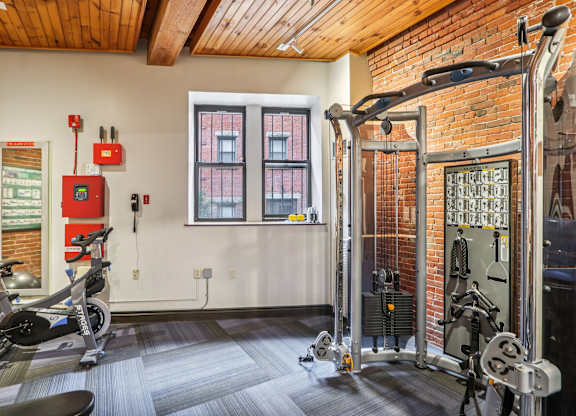 A gym with a wooden ceiling and a brick wall.