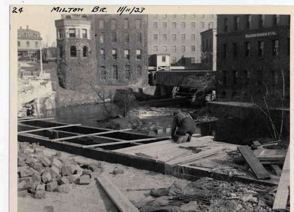 A black and white photo of a construction site for a sidewalk.