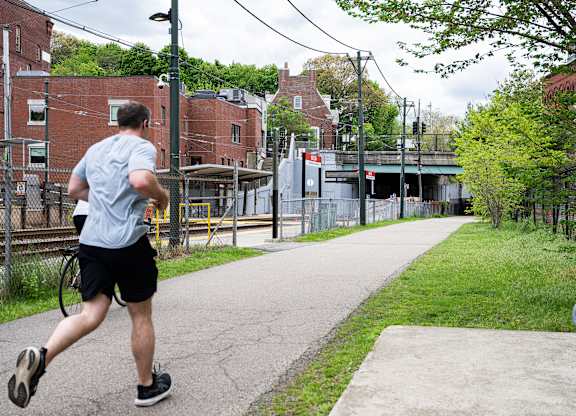 A man running on a sidewalk in a city.