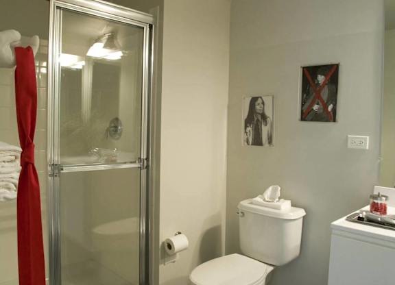 A bathroom with a toilet, a sink, and a shower.at 66 Main, New York