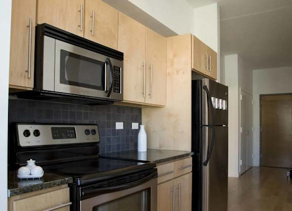 A kitchen with wooden cabinets and black appliances.at 66 Main, Yonkers, NY 10701