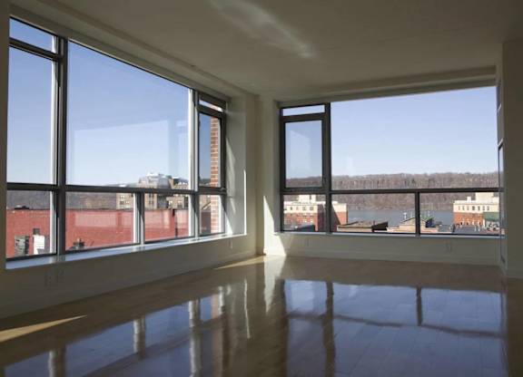 A large empty room with a view of the outside through large windows.at 66 Main, New York, 10701
