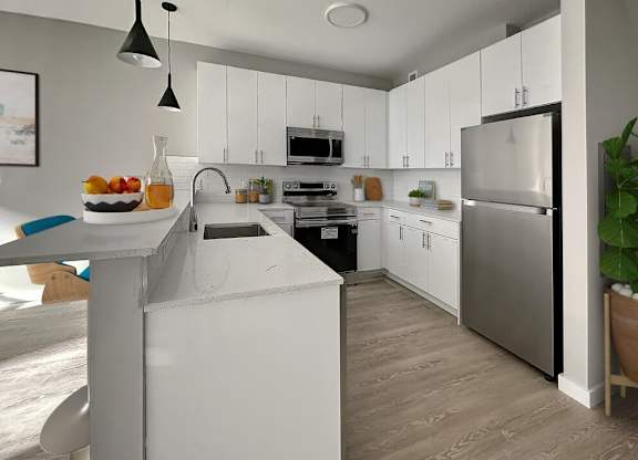 A modern kitchen with white cabinets and a large island.