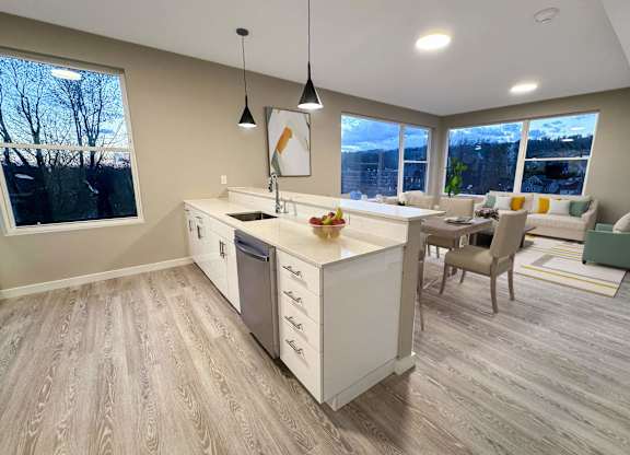 A kitchen with a white counter and a dining table with chairs.