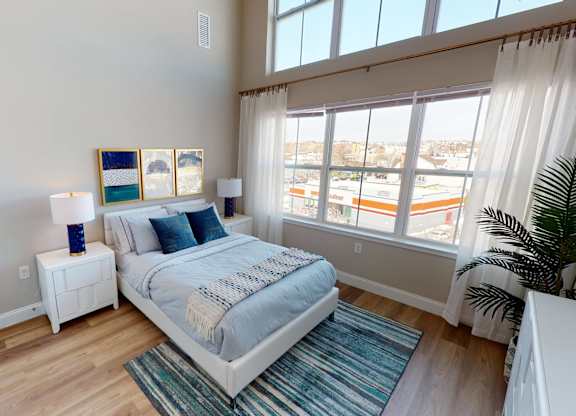 A bedroom with a large bed and a view of the outside.