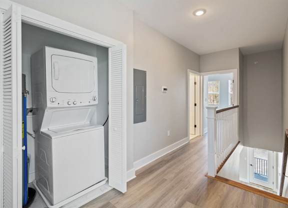 A white fridge and freezer are in a room with wood flooring.