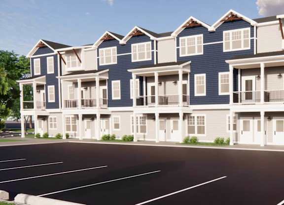 A large blue and white apartment building with a parking lot in front.