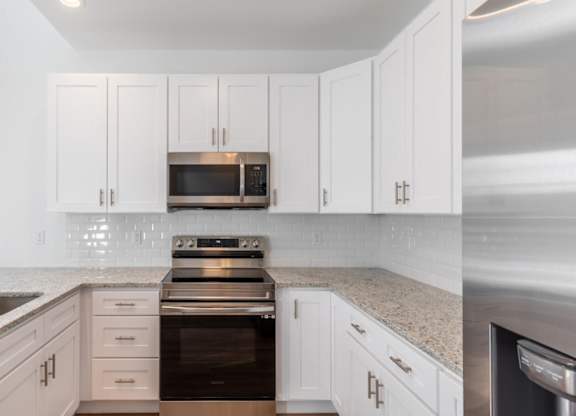 A kitchen with white cabinets and stainless steel appliances.