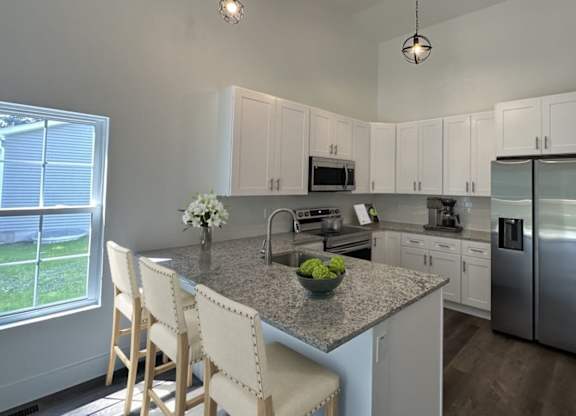 A kitchen with a granite countertop and stainless steel appliances.