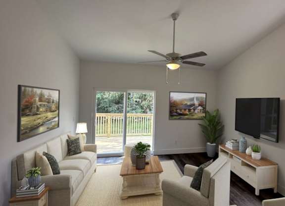 A living room with a couch, a coffee table, a television, and a ceiling fan.