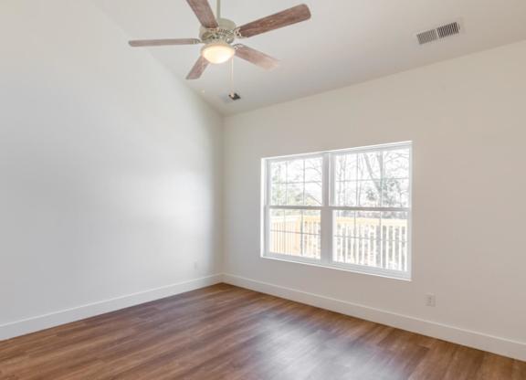 A room with a ceiling fan and a window.