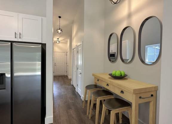 A kitchen with a black refrigerator and white cabinets.