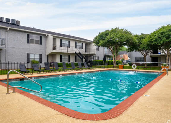 A swimming pool in front of apartment buildings.