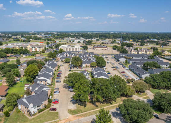 A bird's eye view of a residential area with houses and a parking lot.