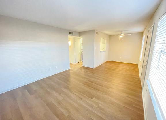 A room with wooden flooring and white walls.