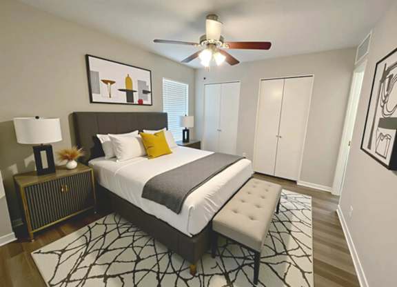 A bedroom with a bed, a ceiling fan, and a rug.