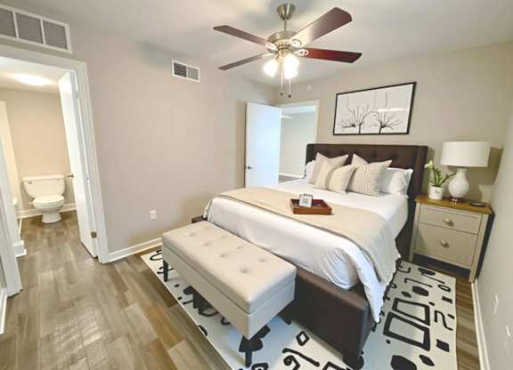 A bedroom with a large bed and a ceiling fan.