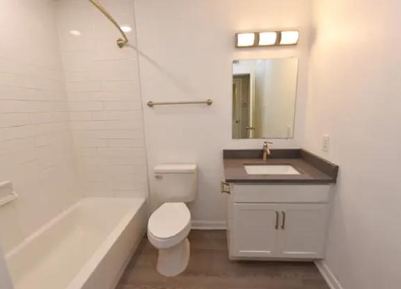 A white bathroom with a toilet, sink, and bathtub.