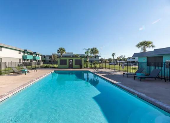 A swimming pool in a sunny outdoor setting.