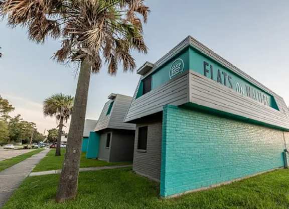 A building with a green roof and a sign that says Flats on Water.