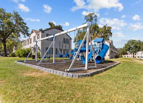 A playground with a blue slide and a white structure.