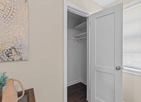 A white door is open to a small, empty room.
