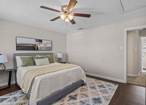 A bedroom with a bed, a ceiling fan, and a rug.