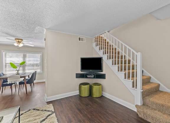 A living room with a staircase leading to the second floor.