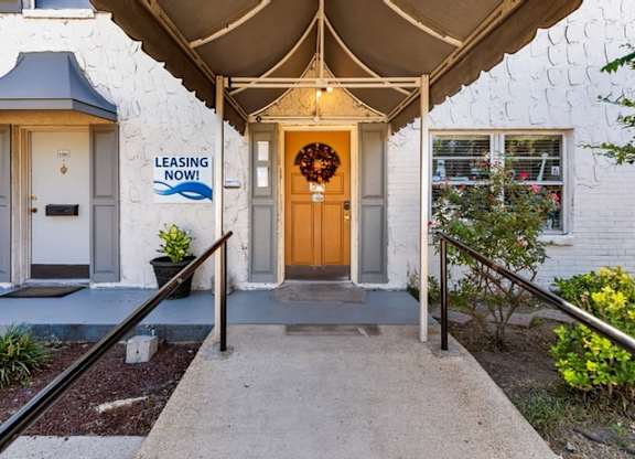 A white house with a leasing sign on the wall.
