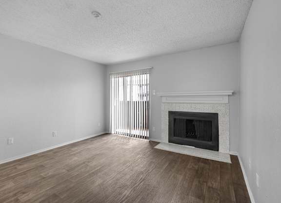 A room with a fireplace and a window with blinds.