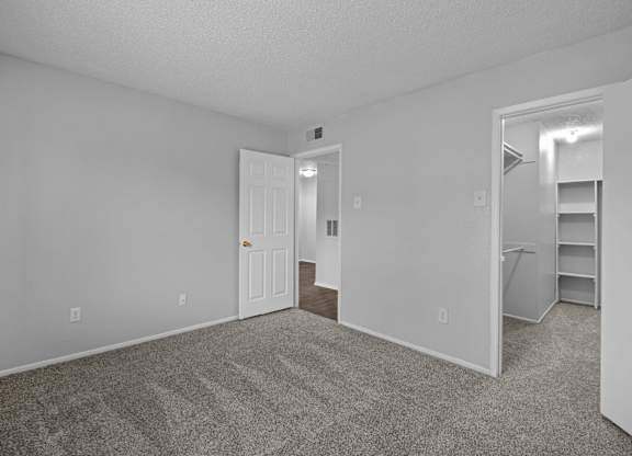A room with a door and a shelf in it.