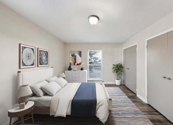 A bedroom with a bed, nightstand, and two framed pictures on the wall.