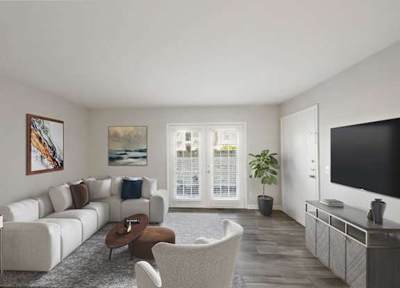 A living room with a white couch, a brown coffee table, and a painting on the wall.