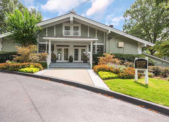 A white house with a porch and a sign that says "GREEN".
